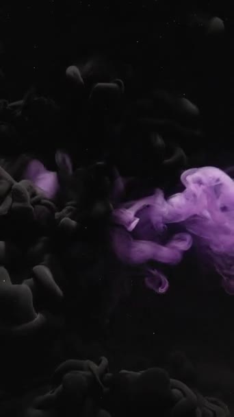 垂直ビデオ インクの水のショット フーム クラウド 水中染料爆発 濃い抽象アートの背景に紫色の黒い色の蒸気ミックスキラキラダスト粒子の動き — ストック動画