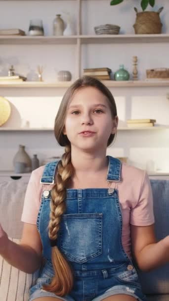 垂直录像 有影响力的孩子Vlog内容 自信聪明的女孩在家里轻便的沙发上摆姿势 分享在线频道的想法 — 图库视频影像