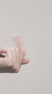 Dikey video. İşaret eden el. Ver onu bana. Ürün isteyen kadın, istenilen ürünü gri boş alanda izole etmek istiyor..