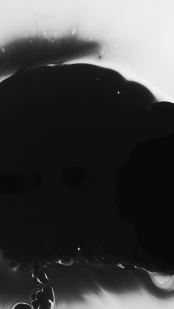 垂直录像 墨水污迹 黑色油漆的设计 神秘的黑暗水传播油滴模式充满创意的动态背景与空旷的空间 — 图库视频影像