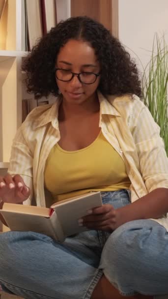 垂直录像 读书的女人家庭图书馆 文学爱好 宁静快乐的女性享受着心爱的书坐在地板上舒适的房间 — 图库视频影像