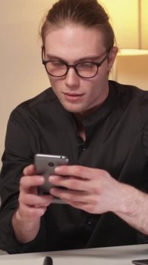 Dikey video. Çevrimiçi zafer. Para ödülü. İnternet kumarı. Sanal bahis. Mutlu ve mutlu bir adam telefon kartı kullanıyor ve evet diyor..