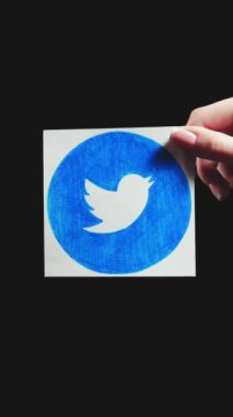 Kharkiv, Ukrayna - 12 Mayıs 2020: Dikey video. Twitter logosu. Çevrimiçi internet ağı. Uygulama işaretini gösteren kadın el, 2 döngünün siyah fotokopi alanı arkaplan setinde izole edildi.