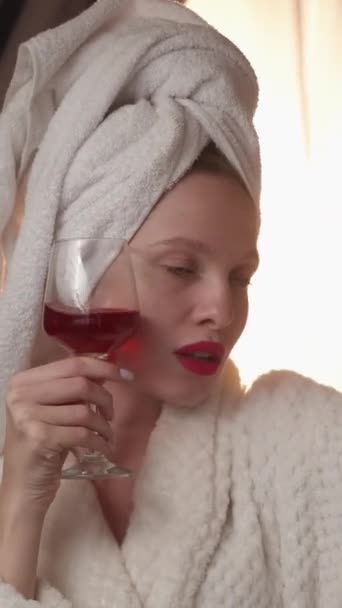 垂直录像 喝自拍 周末的Vlog 奢华的生活社交媒体 穿着浴衣 拿着红酒酒精酒杯在电话摄像机前微笑的有影响力的女人 — 图库视频影像
