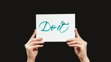 İmzala. Motivasyon mesajı. Siyah boş arkaplanda izole edilmiş, cesaret verici slogan metni gösteren kadın elleri.