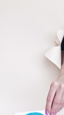 Kharkiv, Ukrayna - Haziran 04, 2020: Dikey video. Twitter simgesi. İnternet uygulaması. Kadın takipçi el beyaz yırtık arka planda sitenin logosunu gösteriyor..