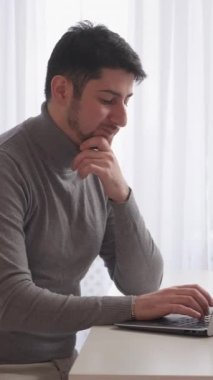 Dikey video. Düşünceli müteahhit. Remore ofisi. Programlama sorunu. Evdeki masaüstü bilgisayarında veri kodu hatasıyla karıştırılmış laptopta yazan düşünceli iş adamı serbest çalışan.