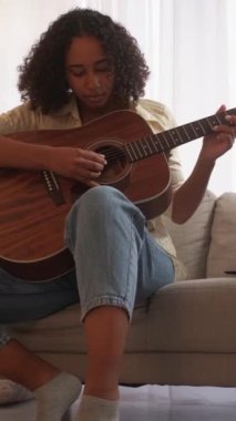 Dikey video. Gitarist. Müzisyen yaşam tarzı. Şarkı alıştırması. Sınıfta akustik telle müzik çalan yetenekli bir kadın..