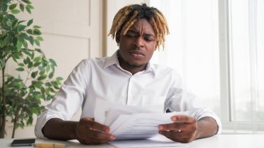 Belge hataları. Ofis evrakları. Kafası karışmış bir iş adamı masasında oturmuş, hafif iç işyerindeki mali rapor sorununu inceliyor..