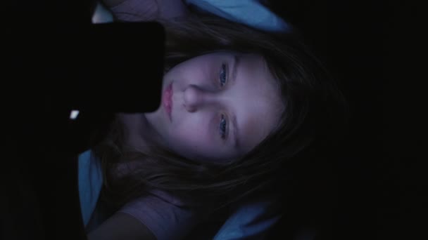 영상입니다 청소년 전화의 소녀가 미디어를 읽으면서 침대에서 내용을 — 비디오