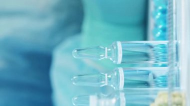 Dikey video. Doktor reçetesi Tıbbi evraklar. Tabletler şişe kabarcıkları ve ampule beyaz masa üzerinde ve doktor el koruyucu lastik eldiven pano yazılı.