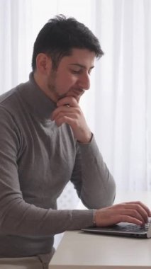 Dikey video. Düşünceli müteahhit. Remore ofisi. Programlama sorunu. Evdeki masaüstü bilgisayarında veri kodu hatasıyla karıştırılmış laptopta yazan düşünceli iş adamı serbest çalışan.