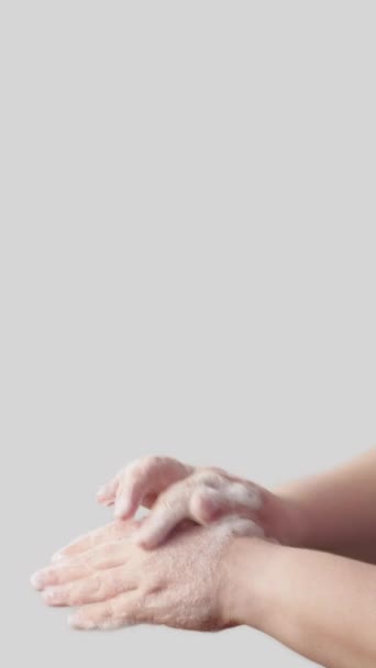 バーティカルビデオ 手洗いする 個人の衛生 白い背景の空のスペースで完全に隔離された抗菌石鹸の泡が付いているヤシの皮を消毒する女性 — ストック動画