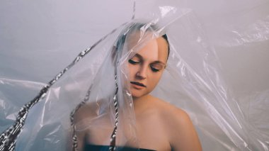 Bilgi sızıntısı. Kişisel veri güvenliği. Beyin yıkama etkisi. Hayal kırıklığına uğramış kadın kafası plastik polietilen filmle izole edilmiş..