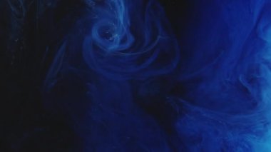 Mürekkep damlası. Renkli duman sıçraması. Açığa çıkarma etkisi. Koyu siyah soyut sanat arka planında mavi duman bulutu patlama dalgası hareketi.
