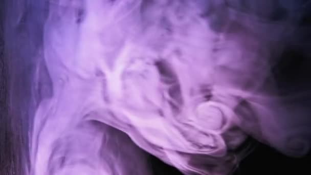 バーティカルビデオ ネオン スモークスプラッシュ マジックパワー 紫色の青色光るフュームパフ雲の動きは暗黒のコピー空間の抽象的な背景に影響を明らかにします — ストック動画