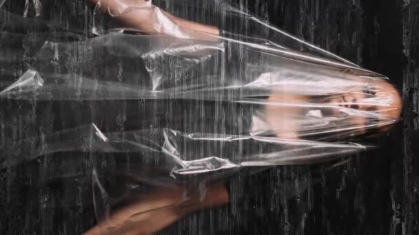 バーティカルビデオ デジタルアート マインドコントロール メディア洗脳 黒い白い光沢のノイズのオーバーレイにプラスチック フィルムを覆う従順な女性の二重露出の分解されたシルエット — ストック動画