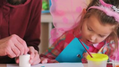 Ebeveyn yardımı. El yapımı çocuk hediyesi. Baba-adam ve yetenekli küçük kız aile zamanı yaratıcı sanat hobisi renkli kâğıt uygulaması..