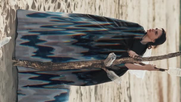 垂直录像 女性孤独 自我隔离 在寒冷的沙滩上 一个满怀信心 满怀希望的女人独自抱住干枯的树 用浮华的噪音动画包裹着 — 图库视频影像