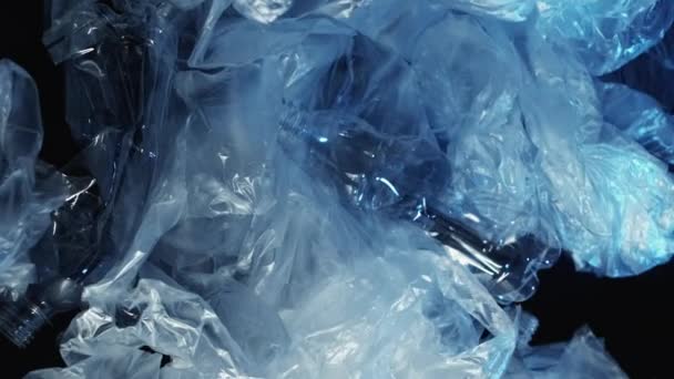 バーティカルビデオ 海洋汚染について エコロジー問題 使用されたぬれたセロファンの袋は黒い背景の風のプラスチックびんのゴミごみを造りました — ストック動画
