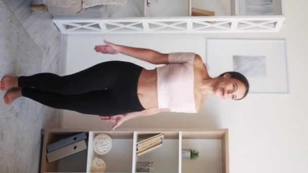 垂直录像 跳杰克 在家锻炼 快乐精力充沛的年轻女子在室内进行运动服训练 把脚和手放在头顶上 — 图库视频影像