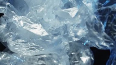 Dikey video. Plastik koleksiyon. Sıfır kayıp. Çöp yönetimi. Rüzgâr şişelerinde ıslak polietilen torbaları kullanılmış. Koyu mavi arka planda çöp yığını..