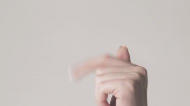 Dikey video. İşaret eden el. Ver onu bana. Ürün isteyen kadın, istenilen ürünü gri boş alanda izole etmek istiyor..