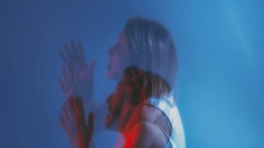 Manik depresif. Depresyon çığlığı. Çifte pozlama kadın silüeti el kaldırıyor umutsuzca bağırıyor mavi neon ışıklı fotokopi arka planında izole edilmiş.