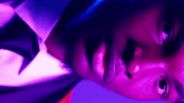 Dikey video. Harika görünüyor. Erkek güveni. Parti tarzı. Mavi mor renkli, açık renkli, smokinli, gururlu, gülümseyen beyefendinin yüzü..