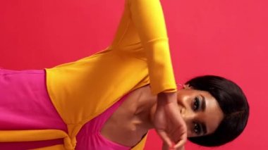 Dikey video. Mutlu danslar. Eğlenceli neşe. Pozitif yaşam tarzı. Heyecanlı, neşeli, güler yüzlü, özgürlüğün tadını çıkaran parlak pembe bir kadın..