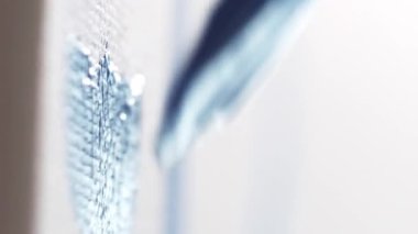 Dikey video. Sanat eseri. Çizim işlemi. Parlak mavi gouache boyalı boya fırçasının yakın çekimi beyaz kumaş tuval üzerinde sanat çalışması yaratıyor.