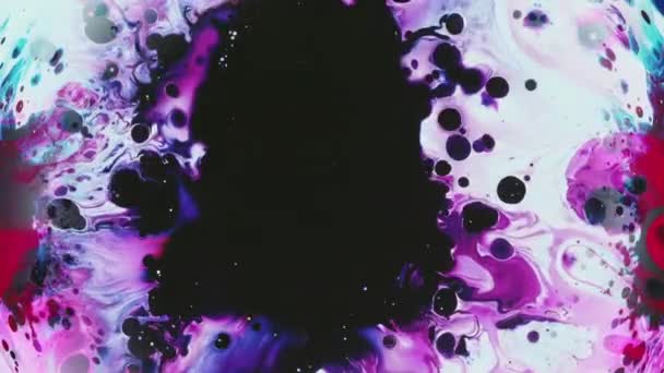 インクが落ちる ペイントスプラッシュ 紫色の赤い黒い液体の混合物は表面の水彩のスパッターの抽象的な背景に広がりました — ストック動画