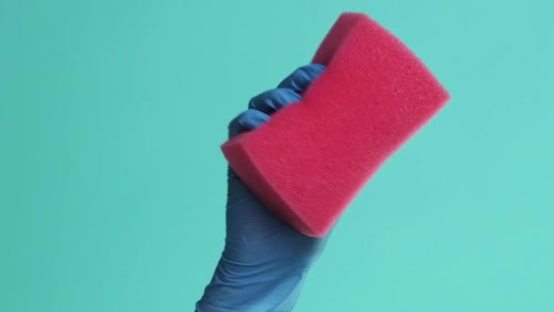 バーティカルビデオ ハウスワーク機器 完璧なクリーニング 緑の背景で隔離されたピンク吸収スポンジワイパーを粉砕する化学保護手袋の専門のジャンパー手 — ストック動画