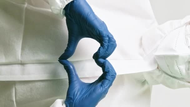 垂直录像 医疗符号 爱的手签名 身穿白色实验室防护服的医生用心形手势罩着蓝色手套 — 图库视频影像