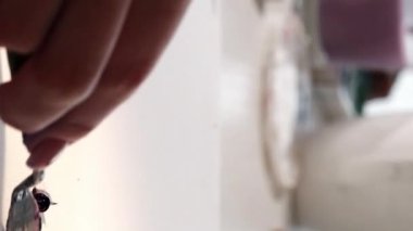 Dikey video. Yağ çizimi. Boyama işlemi. İki kadın sanatçı eli, çalışma odasındaki beyaz tuvalde palet bıçağıyla resim yapıyor..