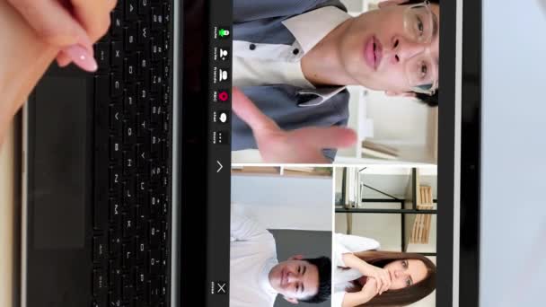 バーティカルビデオ オンラインウェブキャスト 遠隔コミュニケーション オフィスのラップトップスクリーンで話す興奮する同僚との仮想通話で多様な男性の女性ビジネスチーム — ストック動画