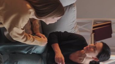 Dikey video. Kızımın desteği. Ebeveyn bağlantısı. Anne genç kız evdeki kanepede birlikte oturarak samimi bir konuşma yapıyor..