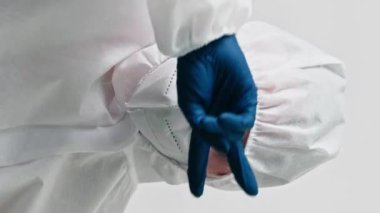 Dikey video. Doktor kutlaması. Tıbbi zafer. Başarıyı iyileştir. Mutlu sağlık uzmanı kadın maske takıyor mavi eldivenler gri arka planda tek başına dans ediyor..