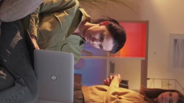 Dikey video. İnternette kullanılıyor. İnternette sörf yapmak. Meraklı kız, annesinin yanından geçen şüpheli bir kadının dizüstü bilgisayarına bakıyor..