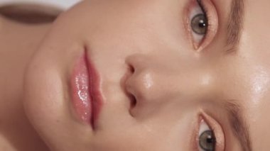 Dikey video. Yaşlanma karşıtı cilt bakımı. Yüz gerdirme prosedürü. Estetik ameliyat. Çıplak makyajlı güzel bir kadın. Kusursuz, genç bir yüz..