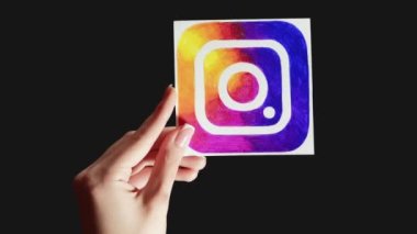 Kharkiv, Ukrayna - 12 Mayıs 2020: Dikey video. Instagram simgesi. Sosyal ağı takip et. Siyah boş arkaplanda izole edilmiş kadın el paylaşım uygulaması işareti.