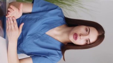 Dikey video. Kadın bir doktor. Tıbbi danışmanlık. Ciddi kadın hemşire, iç mekanda viral hastalıkların önlenmesinden bahsediyor..