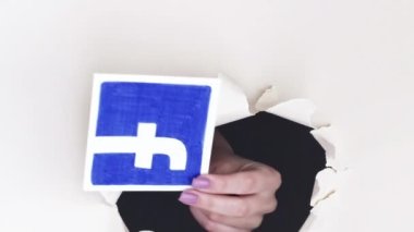 Kharkiv, Ukrayna - Haziran 04, 2020: Dikey video. Sosyal medya logosu. Kadın el paylaşımı Facebook TikTok Instagram Twitter sitesi simgeleri beyaz döngü üzerindeki çığır açan kağıt deliğinden.