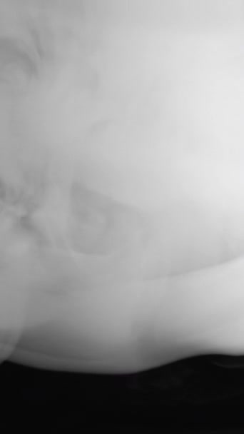 Vertical video. Smoke background. Explosion smog. Vapor puff. White thick fog flow motion on dark black copy space abstract background.