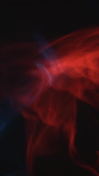 バーティカルビデオ カラー タバコ 蒸気浮遊オーバーレイ ファイヤーアイス 暗黒黒抽象フリースペース背景のぼやけた赤い青い光る発光雲の流れの動き — ストック動画