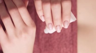 Dikey video. Eller cilt bakımı. Tedavi kozmetik. Besleyici ürün. Sabah rutini. Havluya sarılmış bir kadın duştan sonra cildine nemlendirici krem sürüyor..
