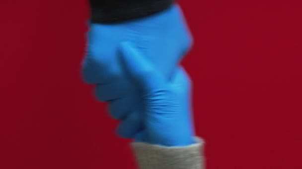 垂直录像 科罗纳威斯的问候大范围握手 一组3名身穿蓝色防护手套 与红色背景隔离的男性问候者 — 图库视频影像