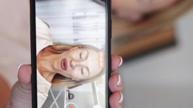 Dikey video. Blogcu kadın. Vlog kaydı. Mutlu bayan akıllı telefon ekranında sosyal medya içeriği yaratıyor..