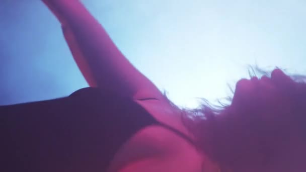 バーティカルビデオ 振付のパフォーマンス ダンサーショー 明るいプロジェクター光の背景で青い霧の影で移動するプロの芸術的な女性 — ストック動画