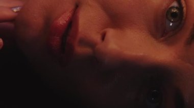 Dikey video. Cilt bakımı. Yüz bakımı. Gizemli güzellik. Besleyici bir tedavi. Şehvetli genç kadın elleri dokunuyor pürüzsüz mükemmel cilde koyu gölgede.